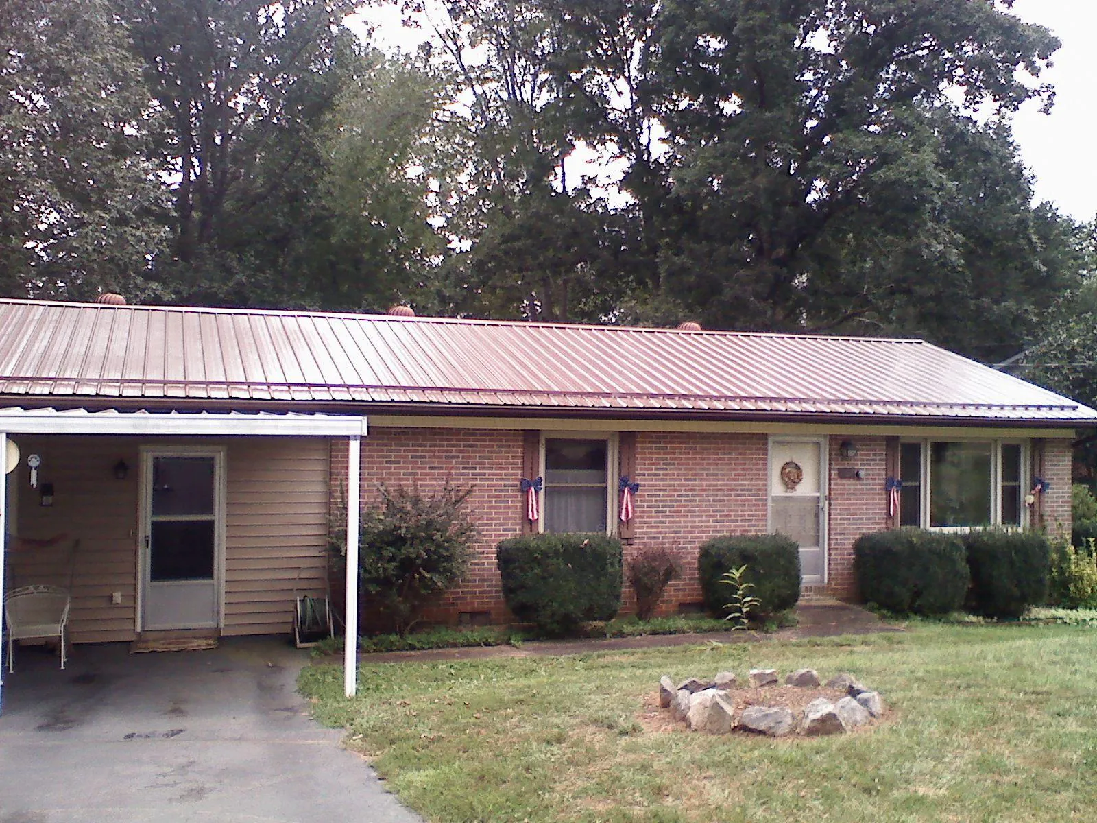 Bronze metal roof and carport on a brick ranch home — Roof Repair work by our crew in Racine