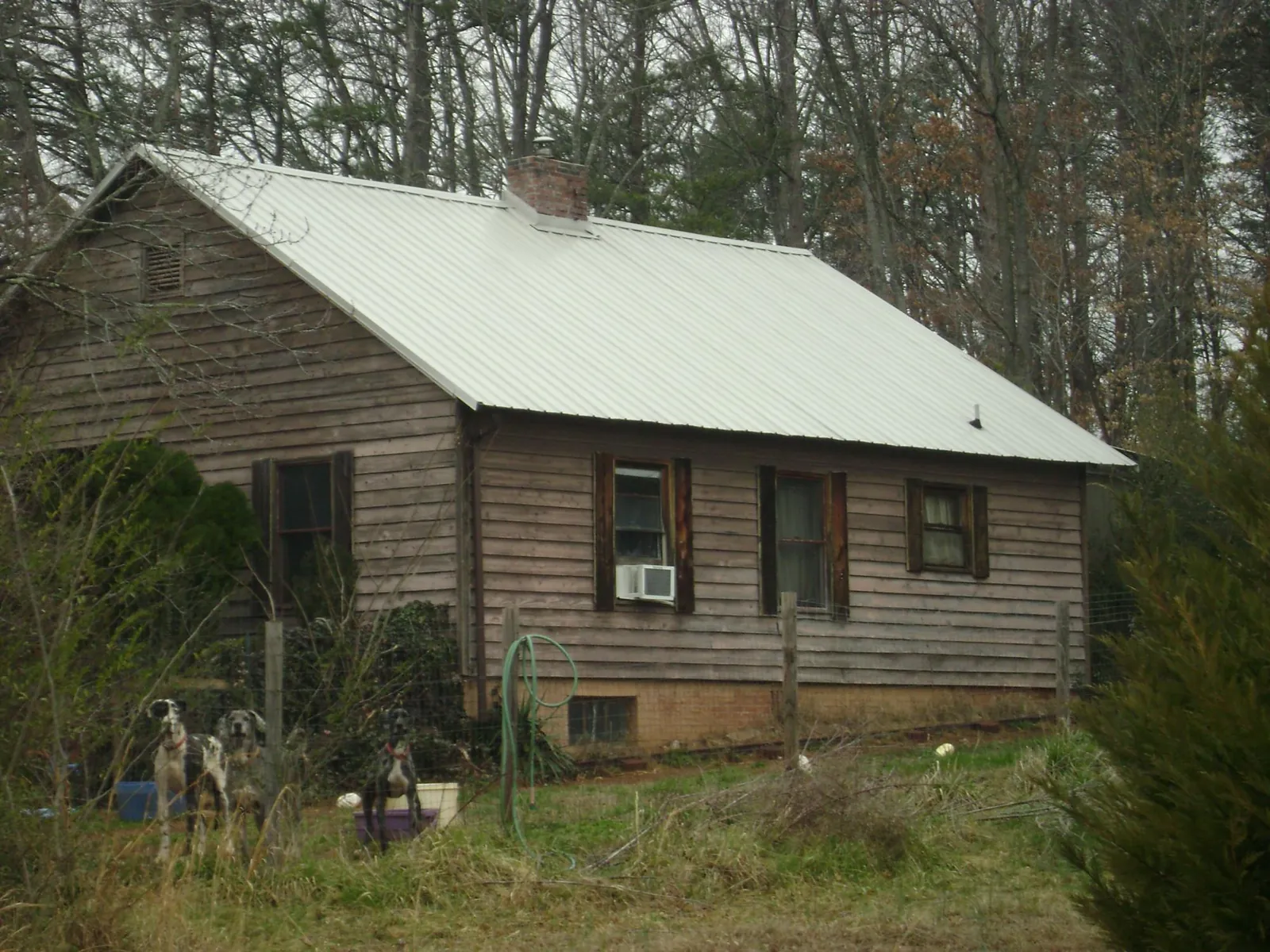 White metal roof on an old wood sided farmhouse, from a Metal Roof Installation job in Racine